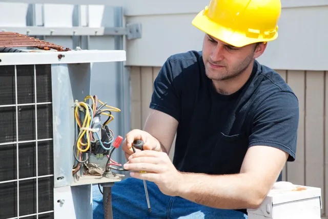 A technician repairing a rooftop condenser unit